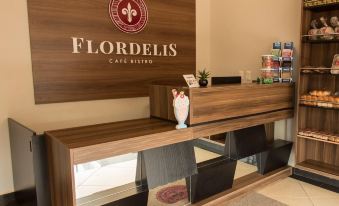 "a reception desk with a large sign on the wall that says "" flordelis cafe bistro "" in white letters" at Nova Hotel
