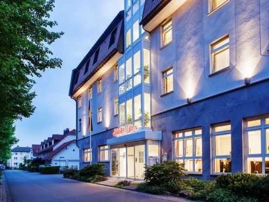 "a modern building with a large glass window and the name "" caritec "" on it , illuminated by the night sky" at Hotel am Dom