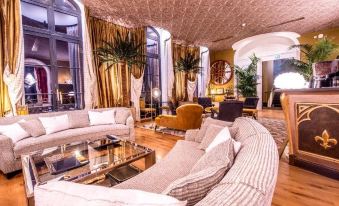 a luxurious living room with multiple couches , chairs , and tables arranged in various seating areas at Chateau de Sacy
