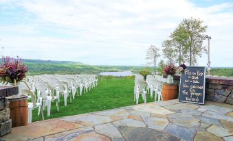 a wedding ceremony taking place on a grassy field with rows of white chairs set up for guests at Mont du Lac Resort