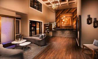 a modern living room with wooden floors and a large chandelier hanging from the ceiling at Aiden by Best Western @ Warm Springs Hotel and Event Center