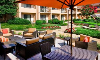 an outdoor patio area with a variety of seating options , including chairs , couches , and umbrellas at Courtyard New Carrollton Landover