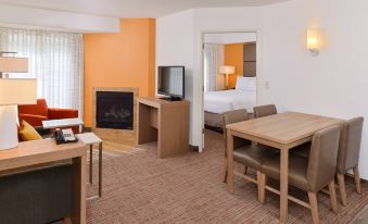 a hotel room with an orange accent wall , a desk , a tv , and a fireplace at Residence Inn Palo Alto Los Altos