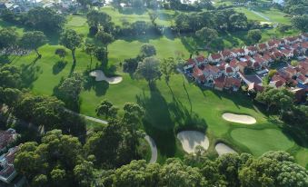 aerial view of a golf course with a large house in the background , surrounded by trees at Joondalup Resort