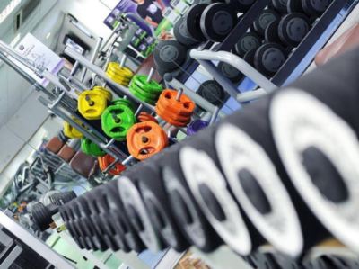 a gym with a variety of colorful weights on the floor , some of which are hanging from the ceiling at Village Hotel Liverpool