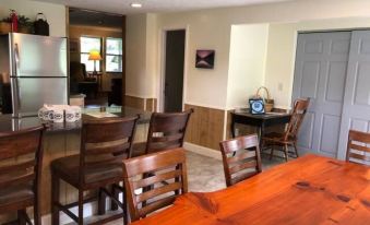 a kitchen with a wooden dining table and chairs , as well as a living room with a couch and television at Opossum Creek Retreat