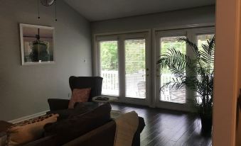 a living room with a couch , chair , and sliding glass doors leading to a balcony at The Waterford