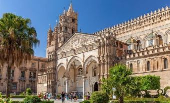 a sunny day in a european city , with a group of people standing outside a large cathedral at Hotel Punta Nord Est