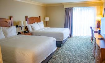 a hotel room with two beds , one on the left side and the other on the right side of the room at Three Rivers Casino Resort