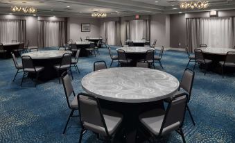 a large conference room with multiple tables and chairs arranged in rows , creating an event space at Homewood Suites by Hilton Newburgh-Stewart Airport