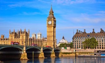 a view of big ben and the houses of parliament in london , with the thames river in the foreground at President Hotel