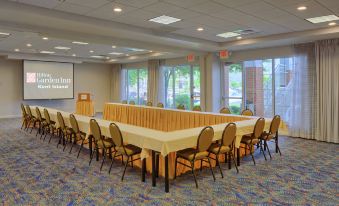 a large conference room with a long table surrounded by chairs and a projector screen on the wall at Hilton Garden Inn Kent Island
