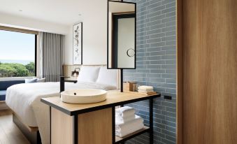 a modern hotel room with a bed , a bathroom , and a mirror on the wall at Fairfield by Marriott Mie Kumano Kodo Mihama