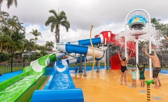 a water park with multiple slides and a large body of water , where people are enjoying themselves at Discovery Parks - Townsville