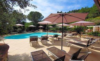 a large outdoor pool surrounded by lounge chairs and umbrellas , providing a relaxing atmosphere for guests at El Patio Hotel