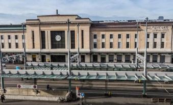 a large building with a clock on the side and people riding bikes on the street at Hotel Admiral