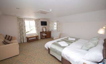 a hotel room with two beds , one on the left side of the room and the other on the right side at The Chequers Inn