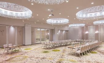 a large conference room with rows of chairs arranged in a semicircle , and a chandelier hanging from the ceiling at Titanic Deluxe Lara