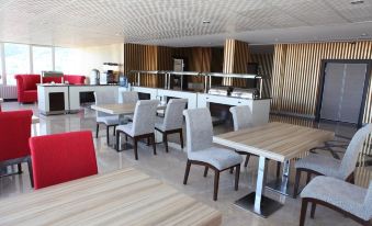 a dining area with several tables and chairs , some of which are occupied by people at Mostar Hotel