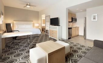 a modern bedroom with a large bed and a flat - screen tv mounted on the wall at Homewood Suites by Hilton Salt Lake City Draper