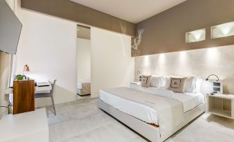 a modern bedroom with a white bed and a bathroom next to it , all in a minimalist style at Best Western Plus Hotel Terre di Eolo
