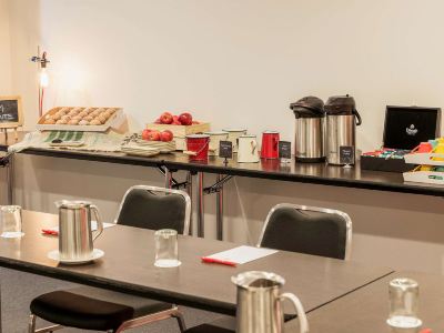 a dining table set with a variety of food items and utensils , including cups , bowls , spoons , and forks at Ibis Melbourne Hotel and Apartments