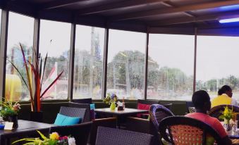 a restaurant with a view of the city , where people are sitting at tables and enjoying their meals at Executive Inn