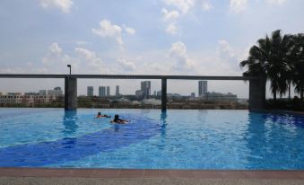 a group of people , including children , are swimming in a large pool with a city skyline in the background at Monaco Hotel