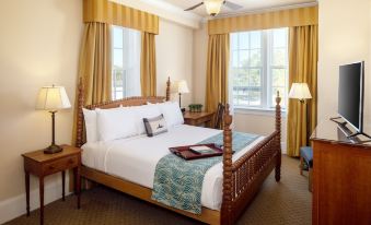 a large bed with a wooden headboard and footboard is situated in a room with yellow curtains at Historic Boone Tavern