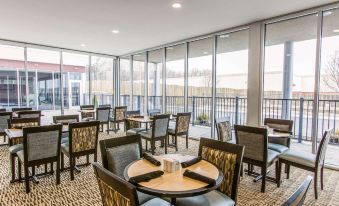 a dining area with several tables and chairs , surrounded by large windows that provide a view of the outdoors at Wyndham Avon