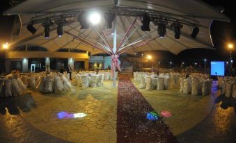 a large tent with tables and chairs set up for an event , possibly a wedding or banquet at Platinum Hotel