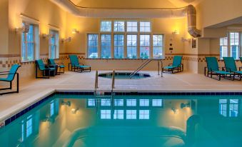 a large swimming pool with a hot tub and chairs in the middle of the room at Residence Inn Richmond Chester