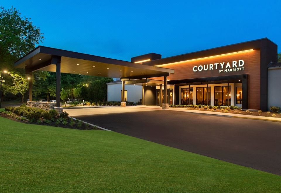 "a modern hotel entrance with the name "" courtyard by marriott "" displayed in large letters above the entrance" at Courtyard Lincroft Red Bank