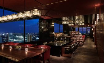 The restaurant features large windows and tables in the center, providing a view of the outdoors from the interior at Hyatt Centric Kanazawa