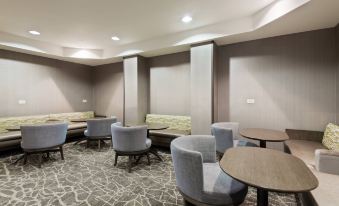 a large , empty room with multiple tables and chairs arranged in a seated arrangement , creating an inviting atmosphere for meetings or gatherings at SpringHill Suites Cleveland Solon