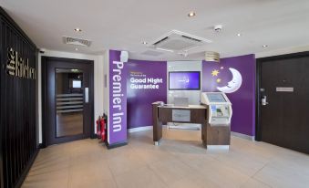 a modern hotel lobby with a purple reception desk and a television mounted on the wall at Penrith