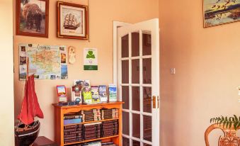 a cozy study space with wooden furniture , including a desk and bookshelves , as well as various books and papers on the table at Ocean Villa