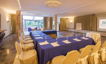 a large conference room set up for a meeting , with chairs arranged in a semicircle around a table at Eden Roc Hotel & Spa by Brava Hoteles