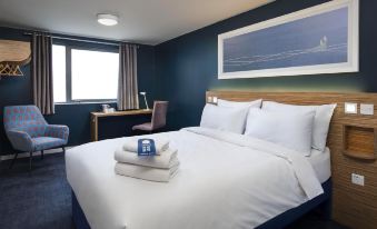 a hotel room with a king - sized bed , a chair , and a painting on the wall at Travelodge Maidenhead Central