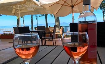 There is a bottle of red wine and glasses placed on the table outdoors at BF Hotel