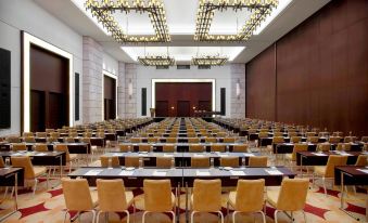 a large conference room with rows of chairs arranged in a semicircle , ready for an event at The Westin Resort, Costa Navarino