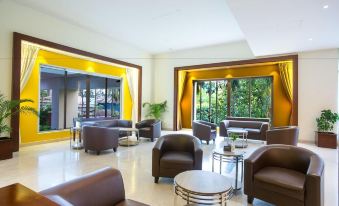 a spacious living room with various seating arrangements , including couches and chairs , arranged in various positions at Hotel Grand Park Barishal