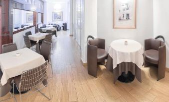 a modern , minimalist interior with wooden floors and white walls , featuring dining tables and chairs at Hotel Boston
