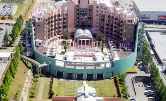 a large , modern building with multiple levels and balconies , surrounded by a lush green garden at Hotel Verde