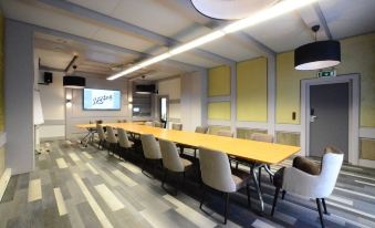 a large conference room with multiple tables and chairs arranged for a meeting or event at Quellenhof