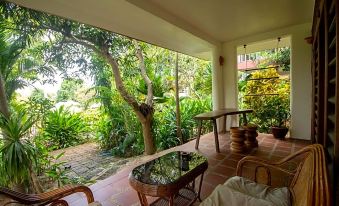 a beautiful outdoor terrace with trees , plants , and furniture , providing a serene and natural atmosphere at Tara Lodge Haven of Peace