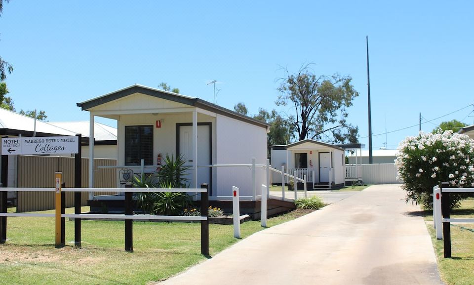 a white house with a red heart on the front is situated on a street at Warrego Hotel Motel Cunnamulla