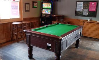 a pool table with a green felt top is in the middle of a room at The Westgate