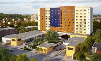 a large , modern hotel building with multiple entrances and a parking lot in front of it at Courtyard Toluca Tollocan