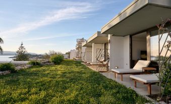 a modern , minimalist house with a green roof and large windows , situated on a rooftop garden at White Rocks Hotel Kefalonia